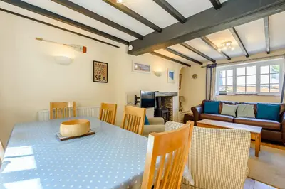 a dining room and living room with a table and chairs at Kynaston Cottage in Aberdyfi