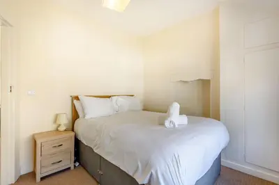 a small bedroom with a bed and a night stand at Kynaston Cottage in Aberdyfi