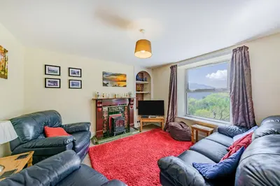a living room with couches and a large window at 2 Isygraig in Corris