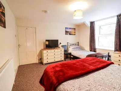 a bedroom with two beds and a tv and a window at 2 Isygraig in Corris