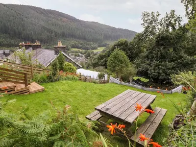a picnic table in the middle of a field with flowers at 2 Isygraig in Corris