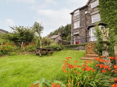 a garden with a picnic table and a house at 2 Isygraig in Corris