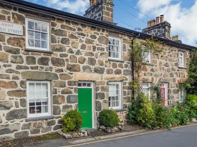an old stone house with a green door at Bro Dawel in Dolgellau