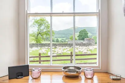 a window with a view of a herd of sheep at Waedog Bach in Llanfor