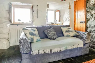 a couch with pillows on it in a living room at Hwylfa'r Groes in Dyffryn