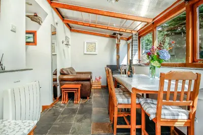 a dining room with a table and chairs at Hwylfa'r Groes in Dyffryn