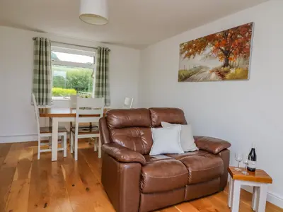 a living room with a leather couch and a table at Foxes Meadow in Llandrindod Wells