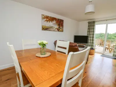 a dining room with a wooden table and chairs at Foxes Meadow in Llandrindod Wells