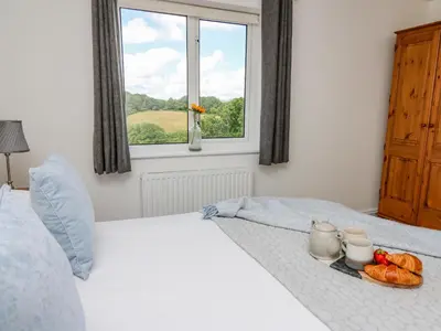 a white bed with a tray of fruit on it at Foxes Meadow in Llandrindod Wells