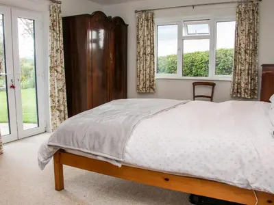a bedroom with a bed and two windows at Bryn Caer in Chirbury