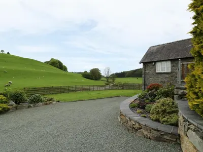 a driveway leading to a house with a green field at Hafan in Llanerfyl