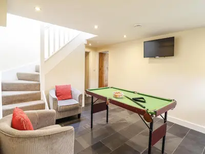 a living room with a pool table and stairs at Beudy Bach Barn in Llanuwchllyn