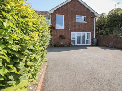 a driveway in front of a brick house at Plum Hill Apartment in Oswestry