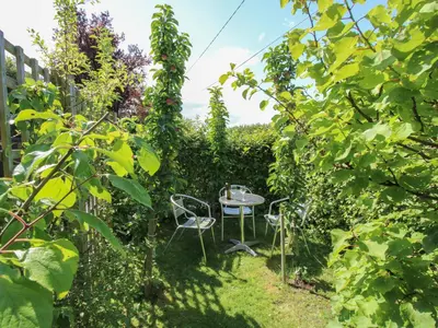 a garden with two chairs and a table in the grass at Plum Hill Apartment in Oswestry