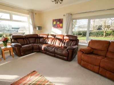 a living room with a leather couch and a chair at Bicton Lea in Acton