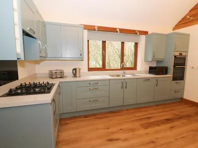 a kitchen with white cabinets and a counter top at Ploony Hill Lodge in Bleddfa