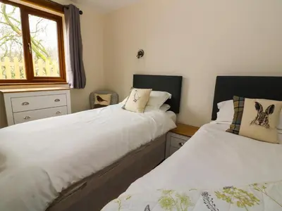 two beds sitting next to each other in a bedroom at Ploony Hill Lodge in Bleddfa