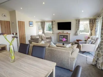 a living room with couches and a table and a television at Clearview Lodge in Borth
