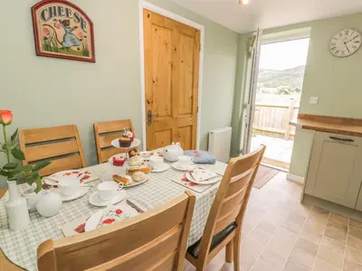 a kitchen and dining room with a table and chairs at Brickfield Cottage in Machynlleth
