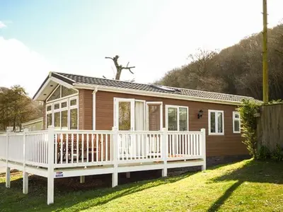 a small house with a porch and a white fence at 73-The Lodge in Llanina