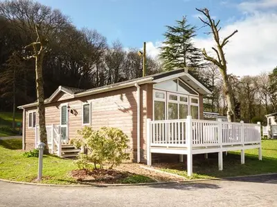 a small house with a porch and a white deck at 73-The Lodge in Llanina