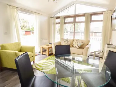 a living room with a glass table and chairs at 73-The Lodge in Llanina