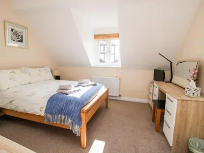 a bedroom with a bed and a dresser and a television at The Wynnstead Annexe in West Felton