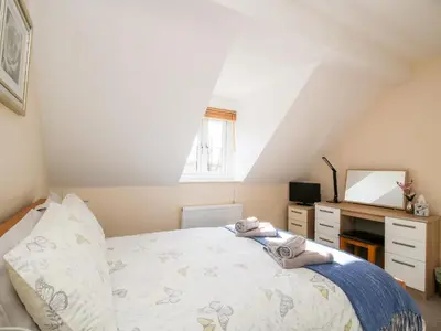 a bedroom with a bed and a desk and a window at The Wynnstead Annexe in West Felton