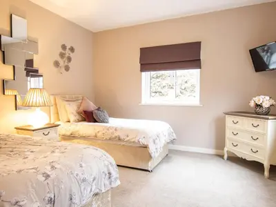 a bedroom with two beds and a window at Moelfre Cottage in Llanbedr