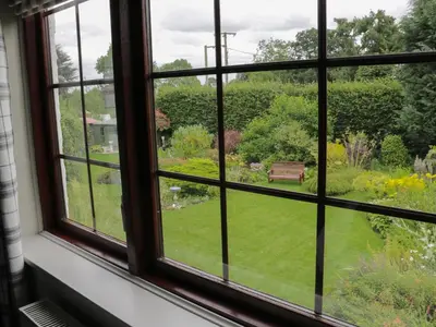 an open window with a view of a garden at Little Beeches in Selattyn