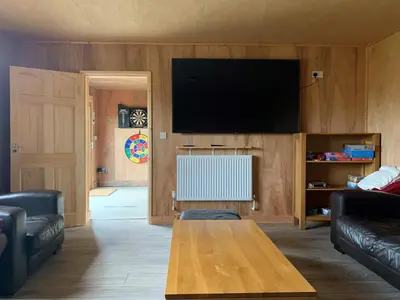 a living room with a table and a flat screen tv at Rolling Hills in Newcastle