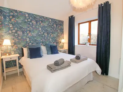 a bedroom with a large white bed with blue pillows at Stoney-Brook Lodge in Farden