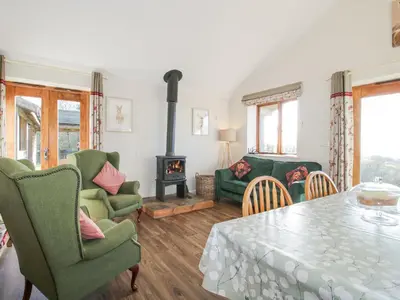 a living room with a table and chairs and a fireplace at Stoney-Brook Lodge in Farden