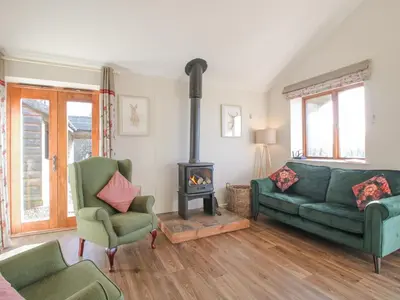 a living room with a couch and a stove at Stoney-Brook Lodge in Farden