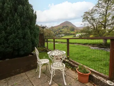 two chairs and a table on a patio with a view at River's Nook in Llangynog