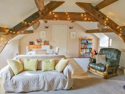 a living room with a couch and a bedroom at Hen Ysgubor Cottage in Bala