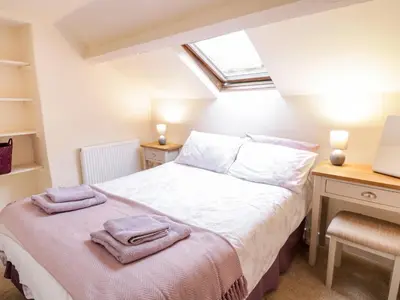 a bedroom with a bed and a desk at Hen Ysgubor Cottage in Bala