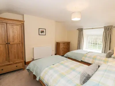 a bedroom with two beds and a window at Llwyn Celyn in Llanfachreth