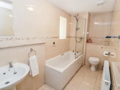 a bathroom with a tub and a toilet and a sink at Yr Hen Dy in Ffestiniog