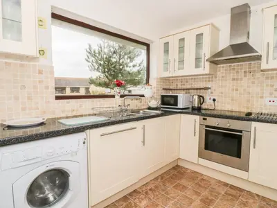 a kitchen with a sink and a dishwasher at Dehangfa in Fairbourne