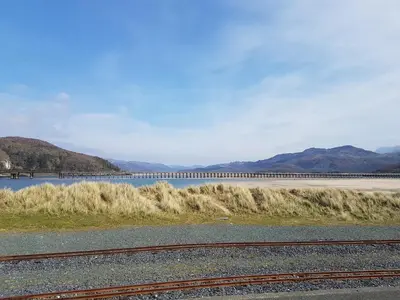 a body of water with a bridge in the background at Dehangfa in Fairbourne