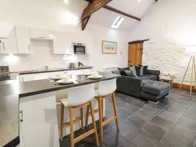 a kitchen and living room with a table and chairs at Cornel Glyd in Dyffryn