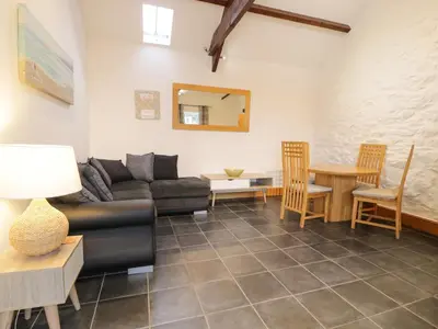 a living room with a couch and a table at Sisial-y-Mor in Dyffryn
