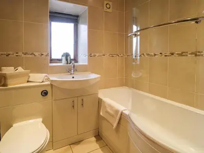 a bathroom with a tub and a toilet and a sink at Sisial-y-Mor in Dyffryn