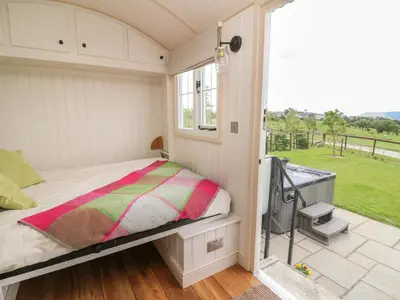 a small bedroom with a bed and a balcony at Shepherd's View in Saint Harmon