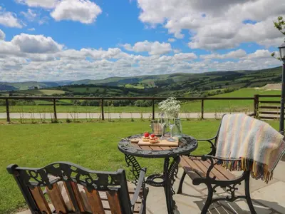 a table and chairs on a patio with a view at Shepherd's View in Saint Harmon