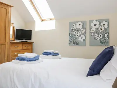 a bedroom with a white bed with towels on it at Ryelands Cottage in Easthope