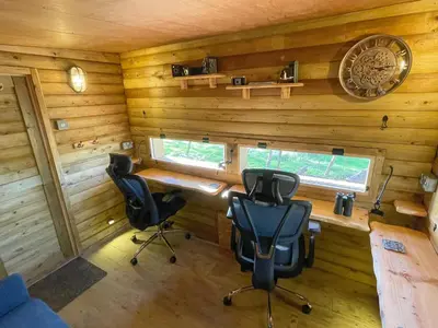 a room with two chairs and a desk in a cabin at Coedmor Cottages in Lampeter