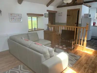 a living room with a couch and a television at Tanyresgair Cottages in Aberystwyth
