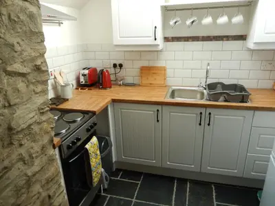 a kitchen with a sink and a stove top oven at Tanyresgair Cottages in Aberystwyth